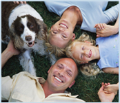 Family with dog laying in grass