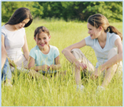 Family sitting in field of grass