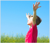 Boy with arms spread in a field